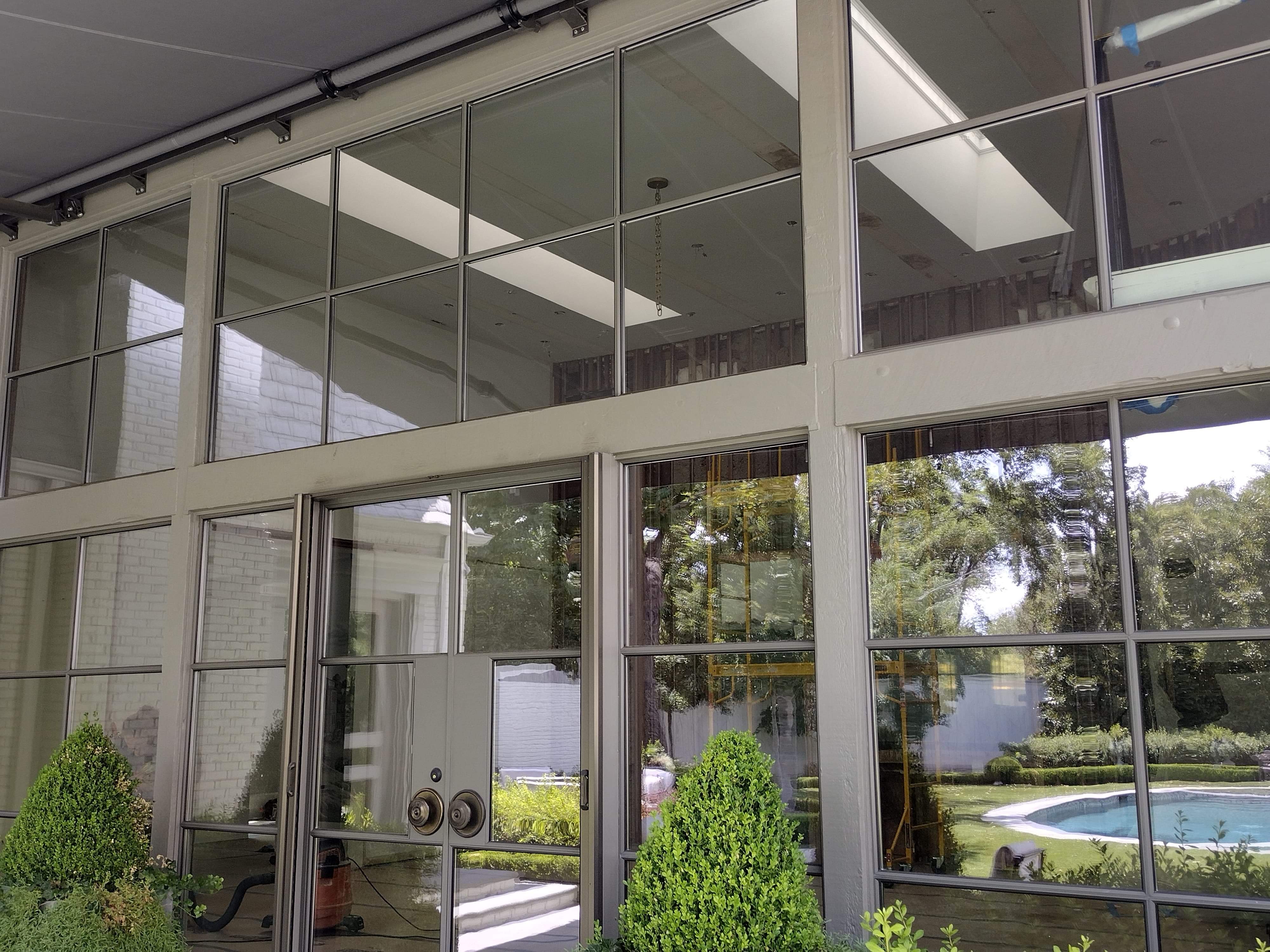 Modern home with floor-to-ceiling tinted windows and pool area