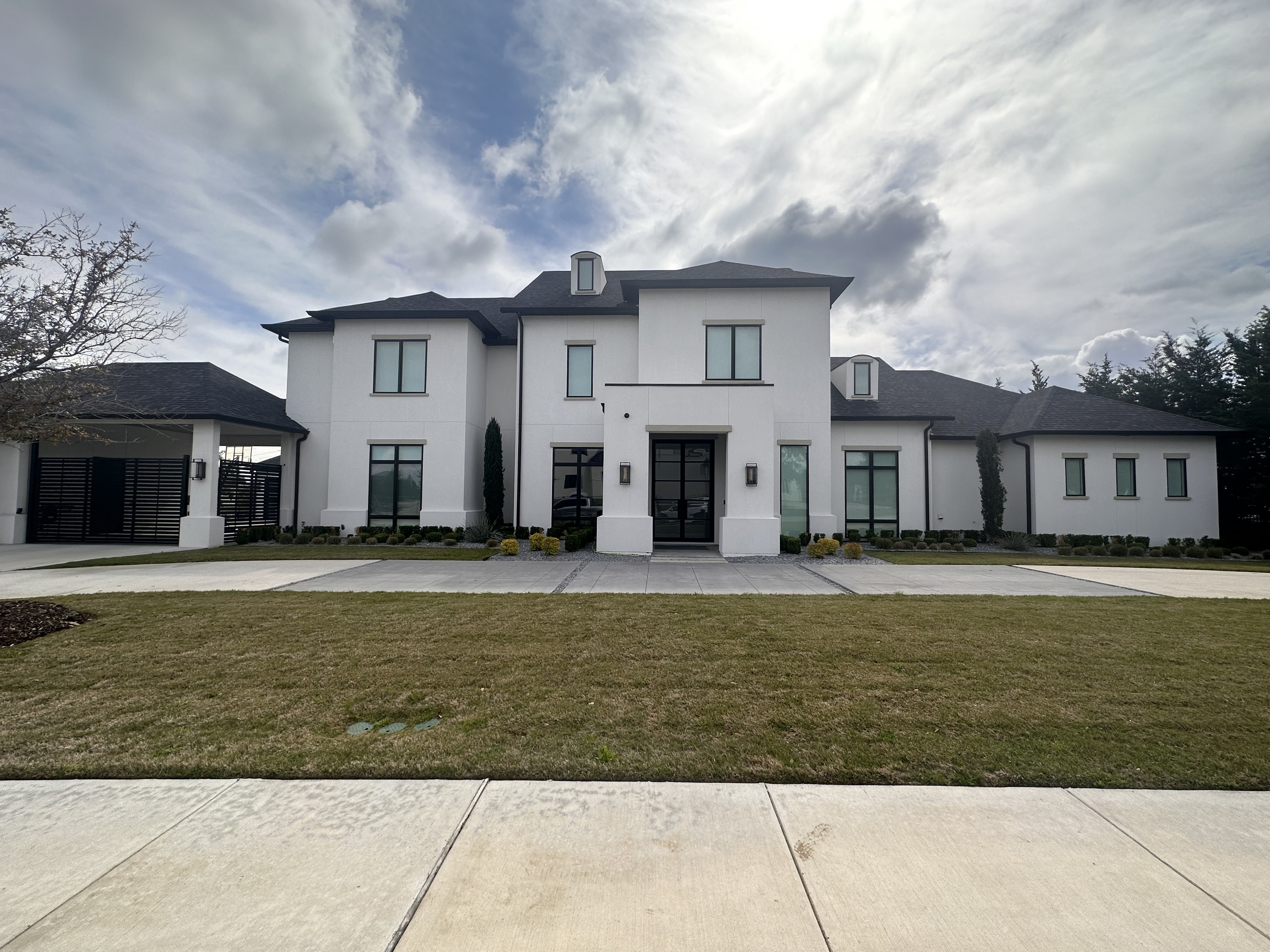 Large modern white estate home with tinted windows