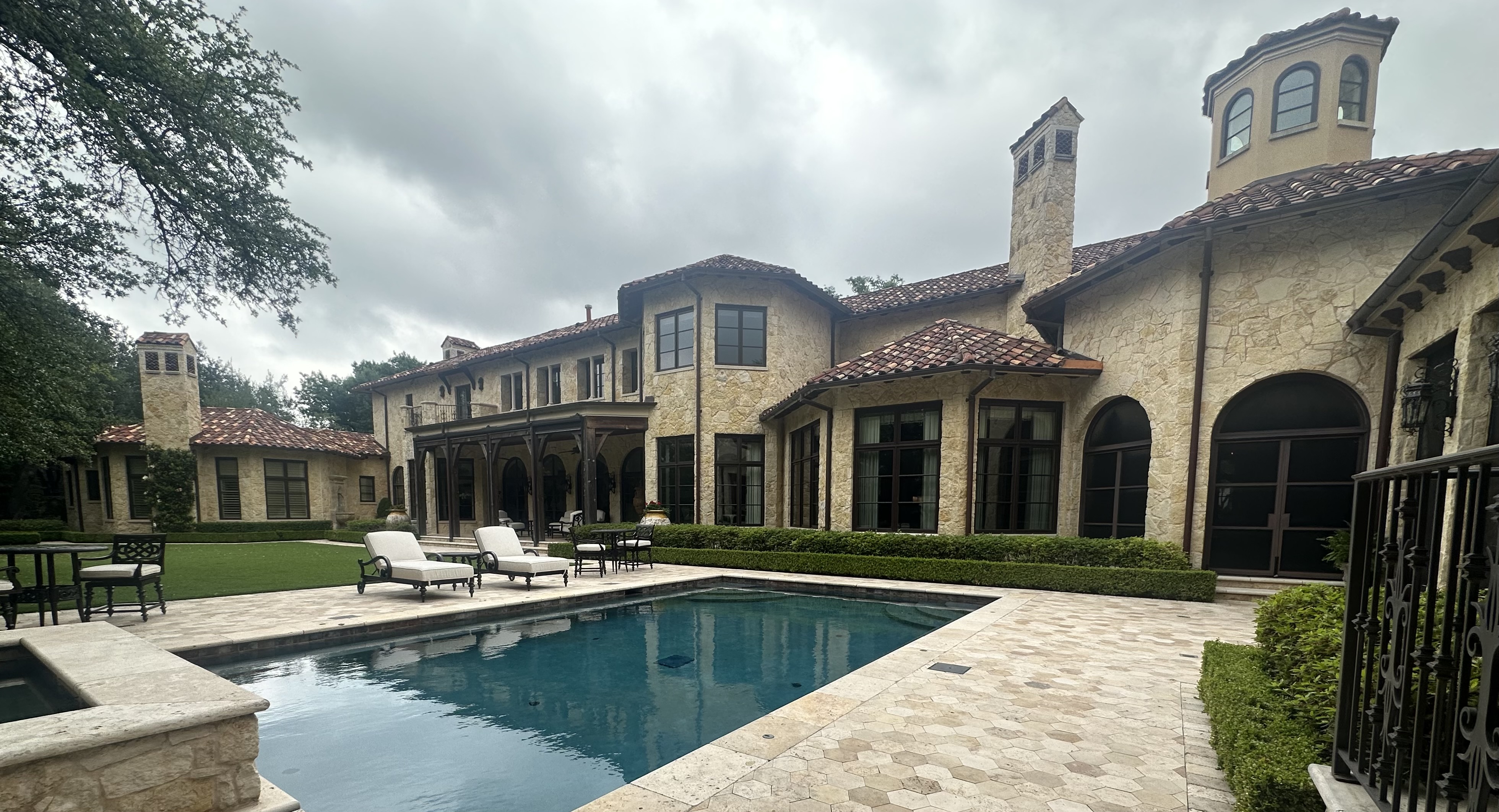 Mediterranean estate with tinted windows and pool area